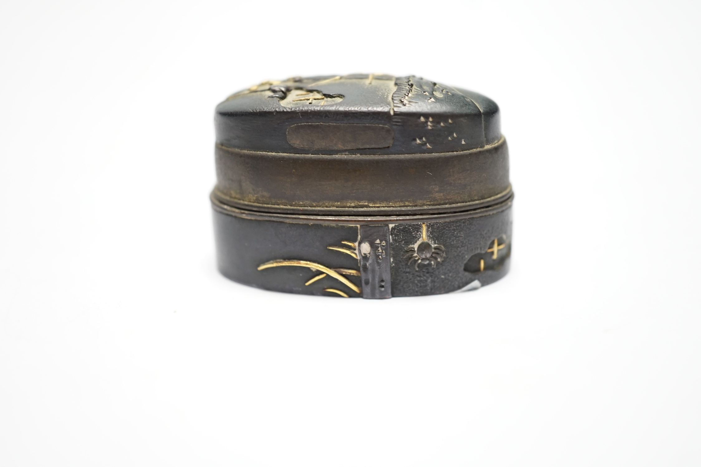 A Japanese mixed metal and bronze box made from 19th century sword fittings, decorated with a spider and web, 4cm